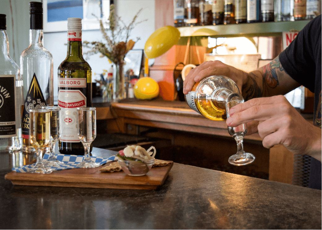 a bartender pouring one of the classic drinks offered at Broder